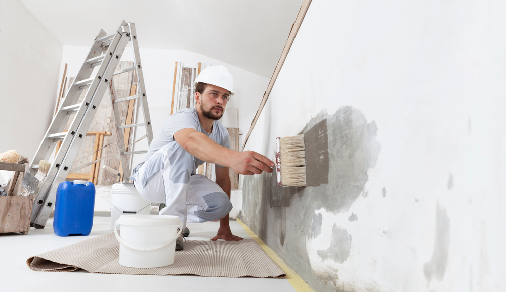 painter using a paint brush on a wall in Suffolk County, NY